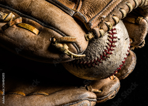 Closeup of old baseball in worn out leather glove