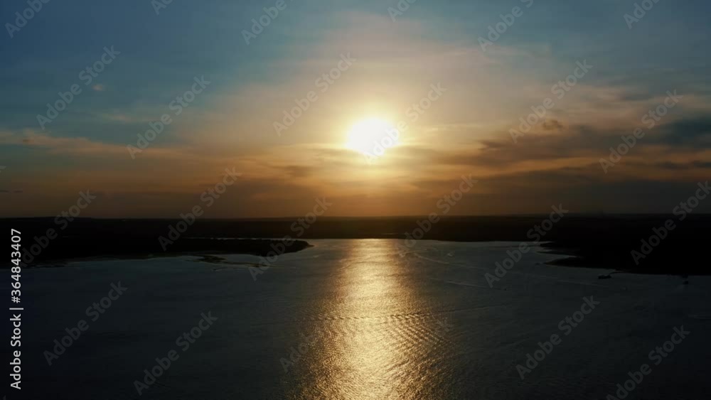 Stunning aerial drone static shot of a golden sunset reflecting onto the water of a large amazonian river in Joao Pessoa, Brazil. Stunning aerial drone static shot of a golden sunset reflecting onto the water of a large amazonian river in Joao Pessoa, Brazil.