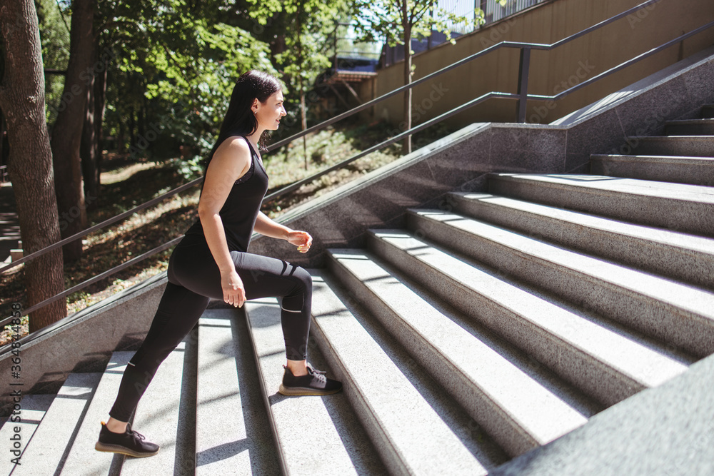 Street fitness, cardio workout, sport in the city. Young fit woman running on the stairs. Endurance and healthy lifestyle