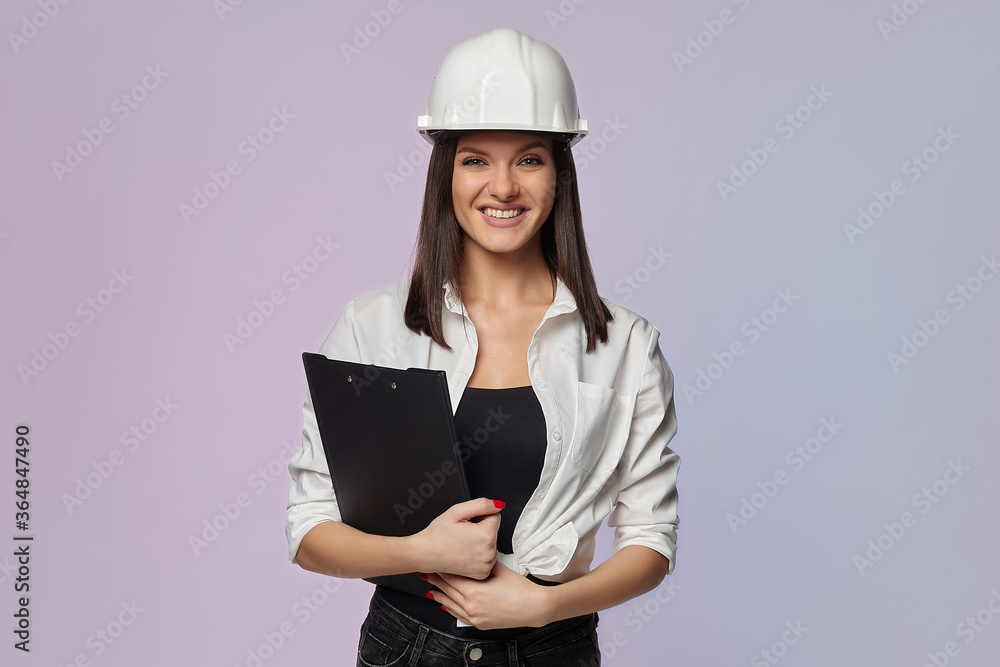 construction girl in a white helmet, holding a folder. the concept of a business woman who understands construction, repair and modernization.. construction girl in a white helmet, holding a folder. the concept of a business woman who understands construction, repair and modernization..