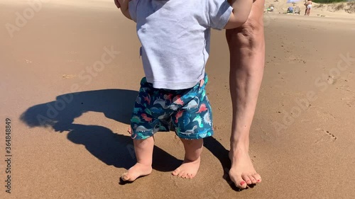 Baby walking at beach shore for first time photo