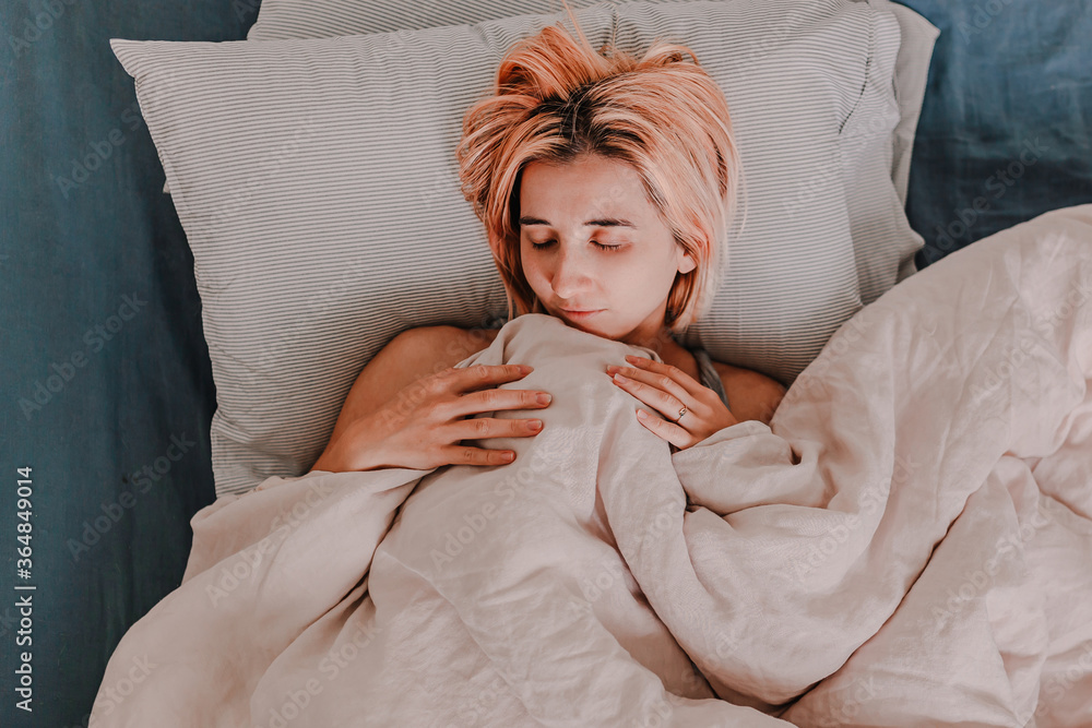 Young woman is relaxing in bed. Day off. Bedtime. Early morning light. White, beige, grey. Light and bright. Morning ritual. Apartment lifestyle living. Cozy bed linen. Taking a nap, sleep. Relaxed Young woman is relaxing in bed. Day off. Bedtime. Early morning light. White, beige, grey. Light and bright. Morning ritual. Apartment lifestyle living. Cozy bed linen. Taking a nap, sleep. Relaxed