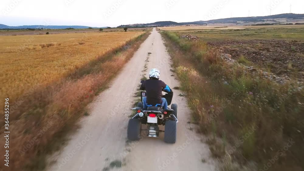 Riding quad bike. Man in protective equipment and helmet, drifting on his ATV at sunset. Aerial footage. High quality 4k footage Riding quad bike. Man in protective equipment and helmet, drifting on his ATV at sunset. Aerial footage. High quality 4k footage