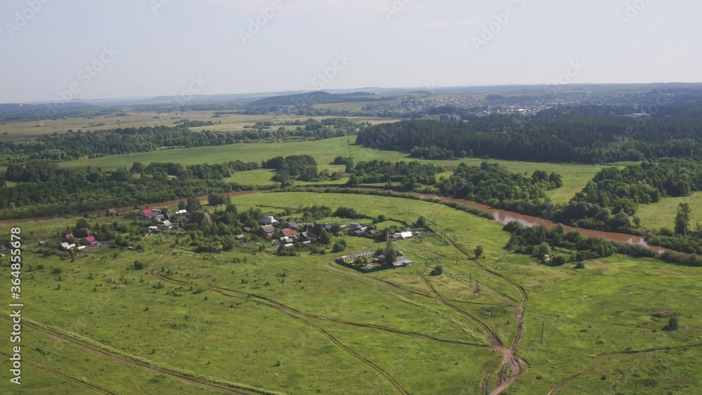 Aerial view russian village on bank of river spring or summer green landscape houses top view on suburb. During the coronavirus lockdown. Forest near village. Top view from drone.