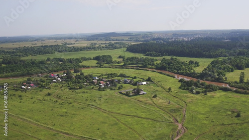 Aerial view russian village on bank of river spring or summer green landscape houses top view on suburb. During the coronavirus lockdown. Forest near village. Top view from drone.