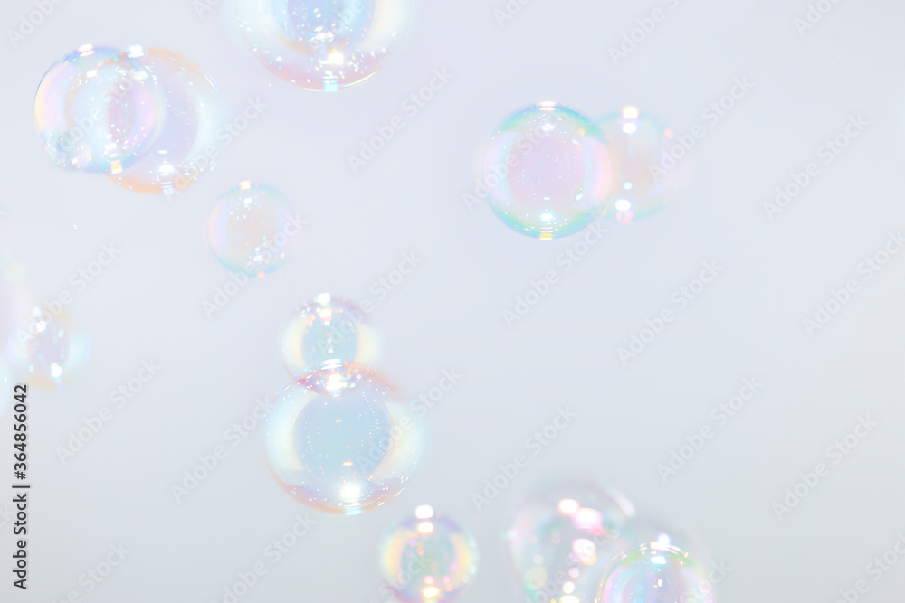 Beautiful rainbow soap bubbles float on white background. Beautiful rainbow soap bubbles float on white background.