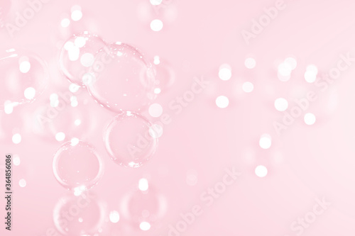 Beautiful clear soap bubbles float on pink background.