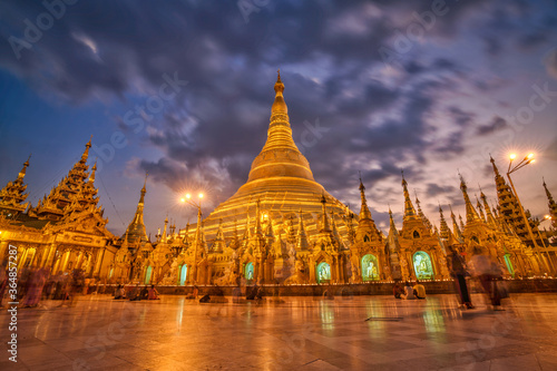 The golden Shwedagon Pagoda during blue hour twilight with dramatic sky cloud © Thanawit