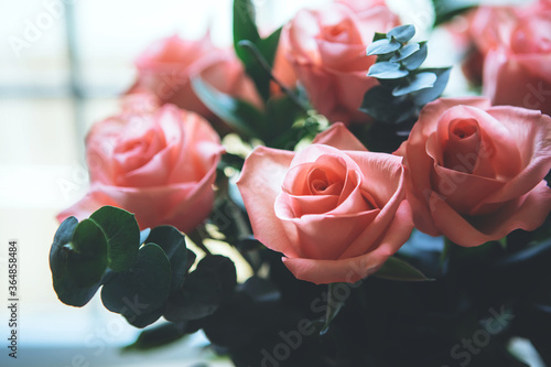 Bouquet of light pink roses on window background. Close up