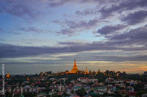 The golden Shwedagon Pagoda during blue hour twilight with dramatic sky cloud © Thanawit