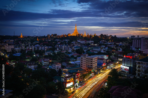 The golden Shwedagon Pagoda during blue hour twilight with dramatic sky cloud photo