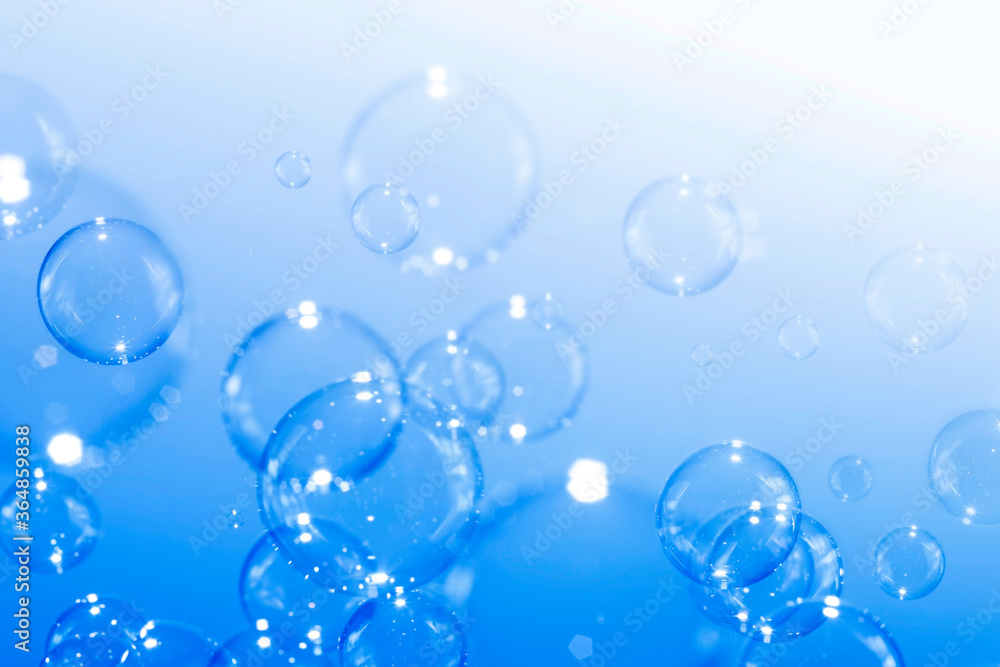 Closeup beautiful clear soap bubbles float on blue background.