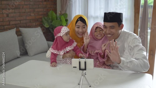 muslim asian family video calling with relatives during eid mubarak using mobile phone photo