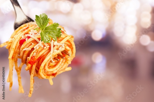 Metal fork with delicious spaghetti and sauce