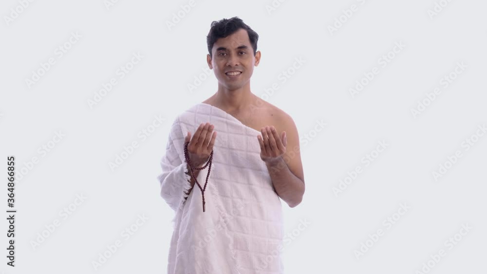 Muslim man praying wearing ihram isolated over white background Muslim man praying wearing ihram isolated over white background