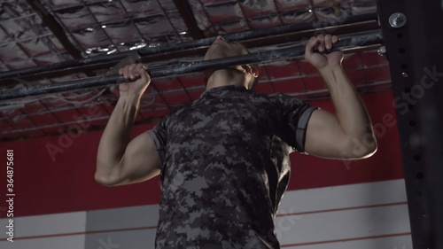 Athletic Young man Doing Pull-Ups in the Hardcore Gym