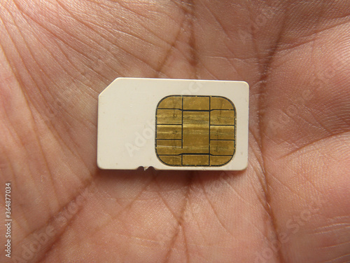 White SIM card on palm of hand photo