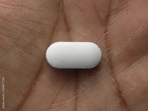 Cuadro en lienzo Small oblong shape white medicine pill on palm of hand