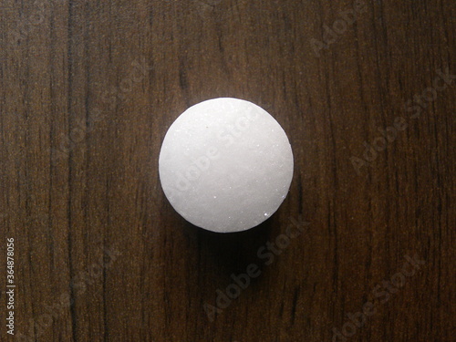 Small white color Naphthalene mothball on wood background