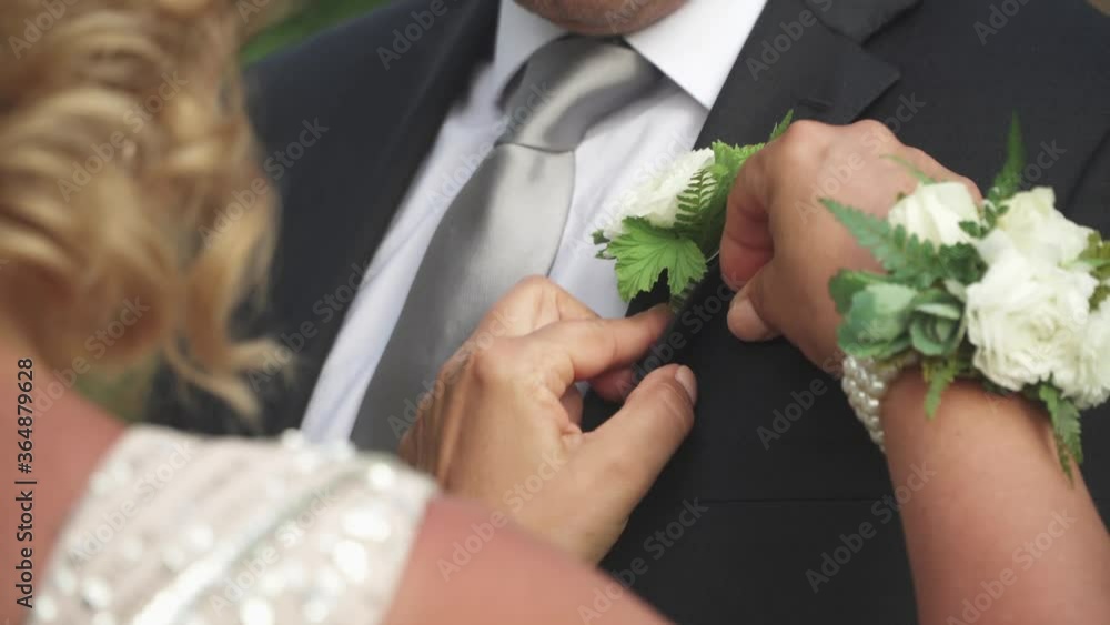 Mother adjusts sons suit on his wedding day. White Rose, over the shoulder. Mother adjusts sons suit on his wedding day. White Rose, over the shoulder.