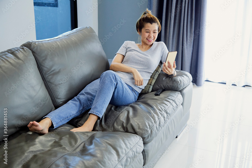 woman relaxing on sofa at home in the living room woman relaxing on sofa at home in the living room