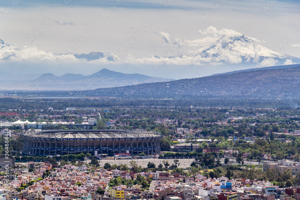 aerial view of azteca stadium and iconic snowed volcanoes in the back