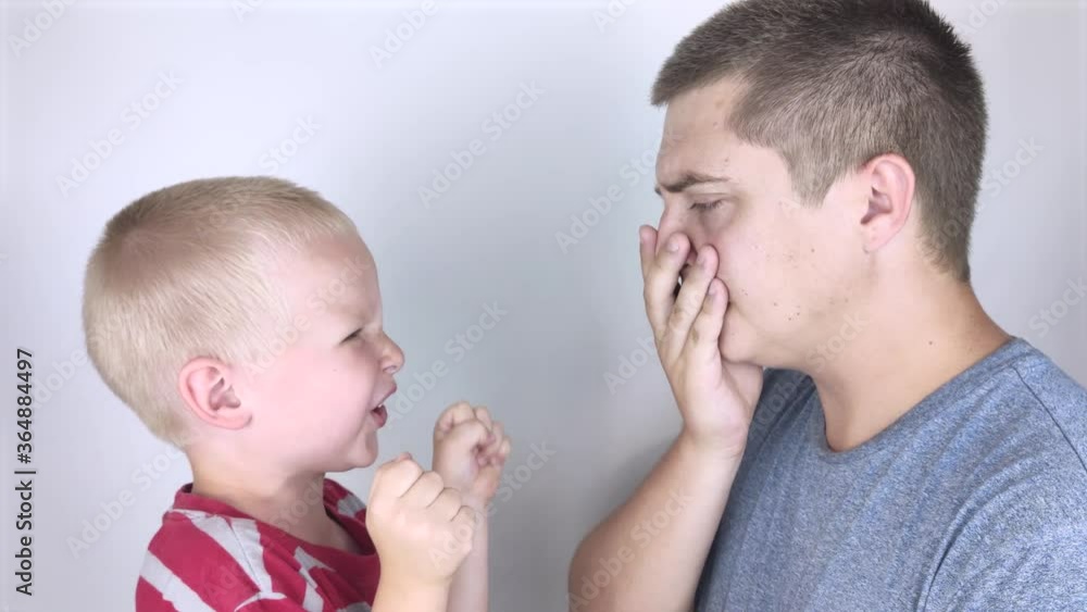 The child waves his fists and yells at his father. Child aggression, family conflicts, a crisis of three to four years. Children's anger and restraint of the father in response. The child waves his fists and yells at his father. Child aggression, family conflicts, a crisis of three to four years. Children's anger and restraint of the father in response.