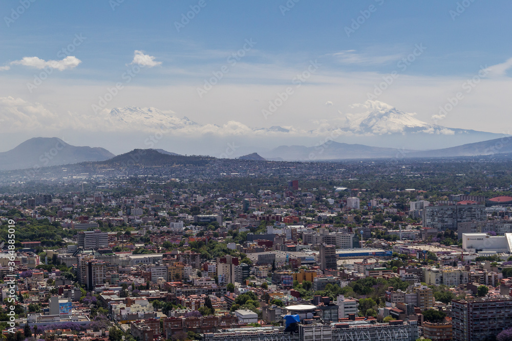 aerial view of typical Mexican living and working area in the southern part of town, with volcanoes in the back