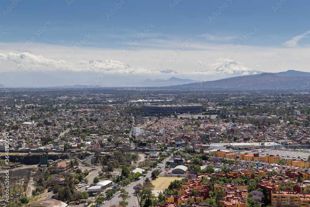 Aerial view of Coapa in Mexico City, with Aztec soccer stadium and snowed volcanoes in the back