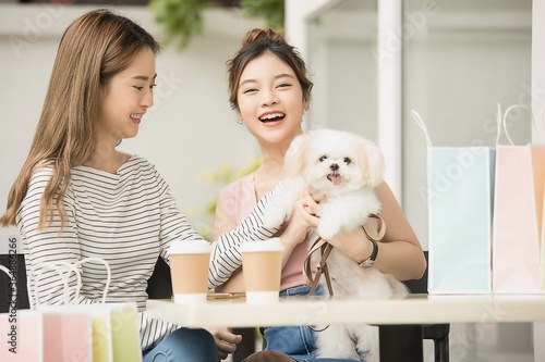 Two young Asian girls are enjoying free time together  and also with a lovely dog