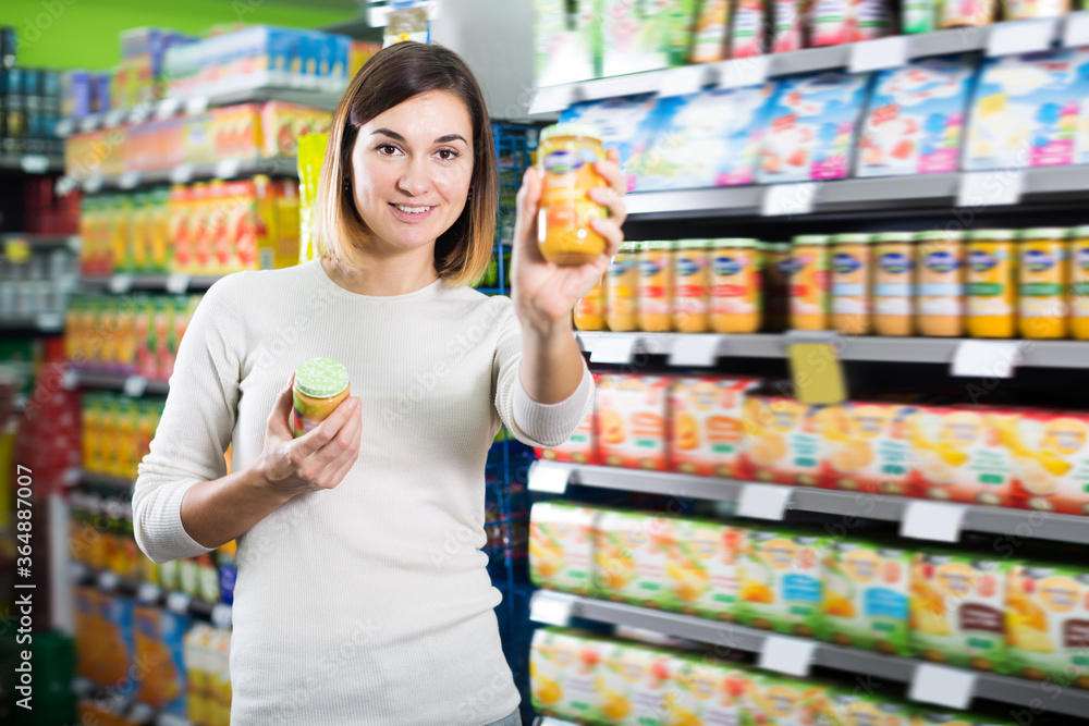 Female shopper searching for baby food in supermarket