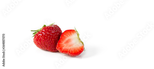A whole and a half red organic juicy  fresh Belgian strawberry isolated on a white background with space for text.