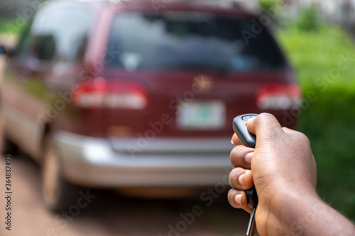 black person using a car remote to unlock a car