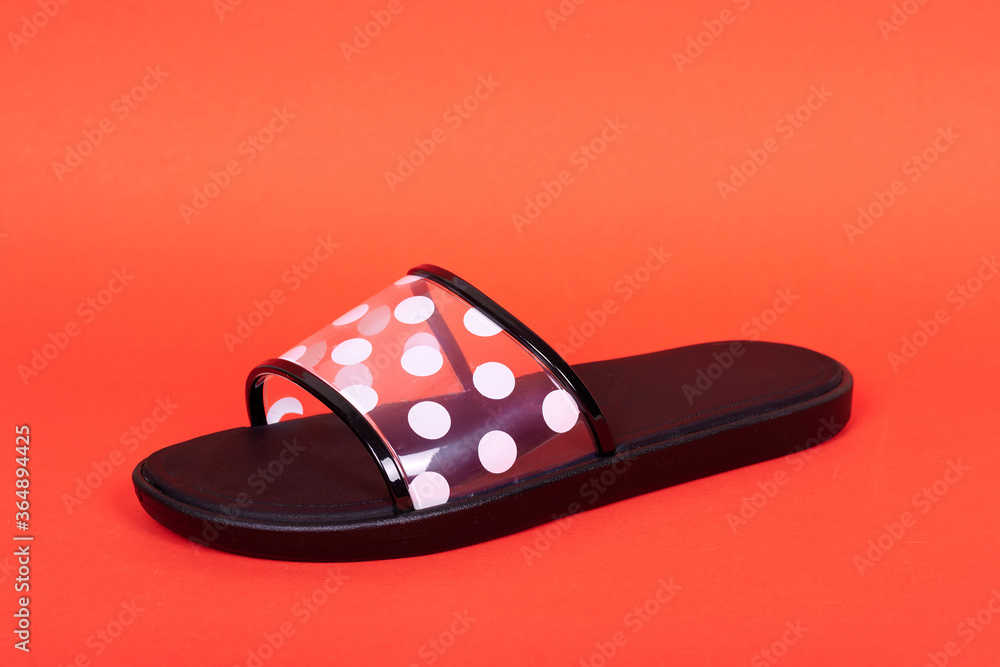 Rubber flip flop with dot pattern. Isolated on red background. Rubber flip flop with dot pattern. Isolated on red background.