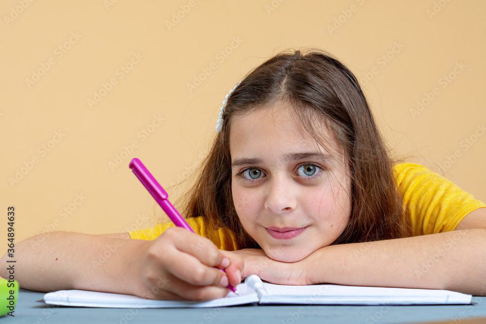 Teen girl studying alone reading textbook sitting at home desk. Adolescent smart teenager school student distance learning with book, making notes Teen girl studying alone reading textbook sitting at home desk. Adolescent smart teenager school student distance learning with book, making notes