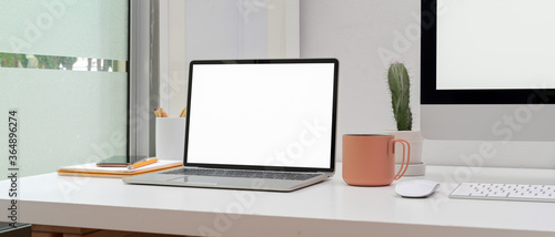Home office with mock up computer, laptop, supplies and decoration on white table