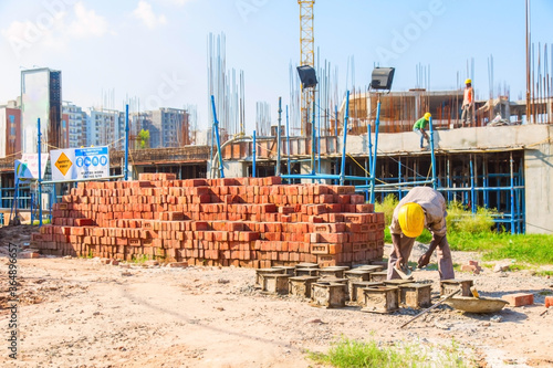 Karnal, Haryana, India - march 2018 : man making up of bricks near the big building in karnal photo