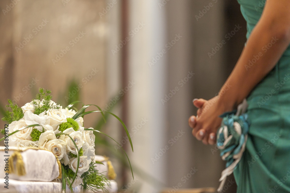 flower bouquet in church and bride in green dress