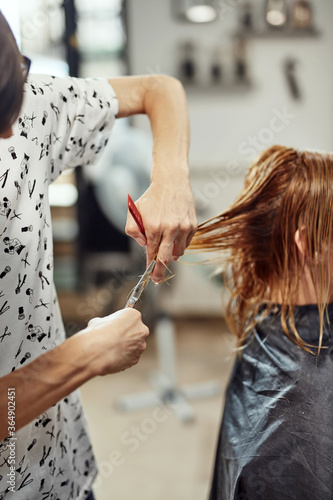 Hair dresser cutting hair in a saloon.