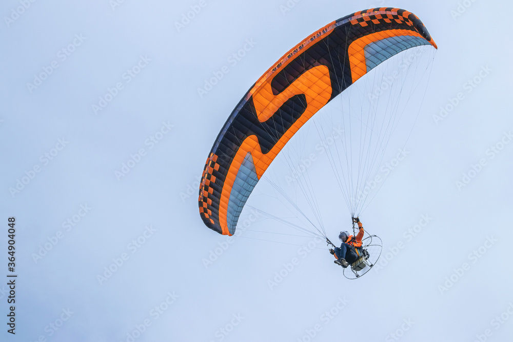 Stockfoto Paraglider with motor and parachute. Flying man on a paraglider.  | Adobe Stock