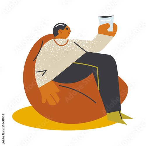 Young man sitting in armchair and enjoying drink on open veranda