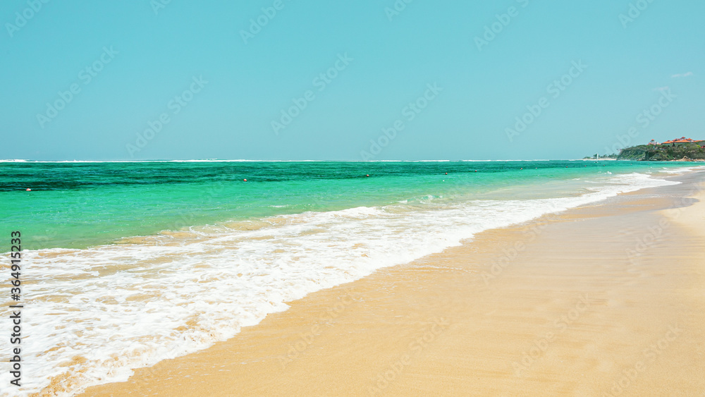 beautiful sandy beach in waves on the ocean coast. Concept of recreation in tropical countries