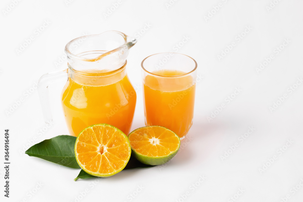 Jug, glass of orange juice and orange fruits with green leaves on white background Jug, glass of orange juice and orange fruits with green leaves on white background