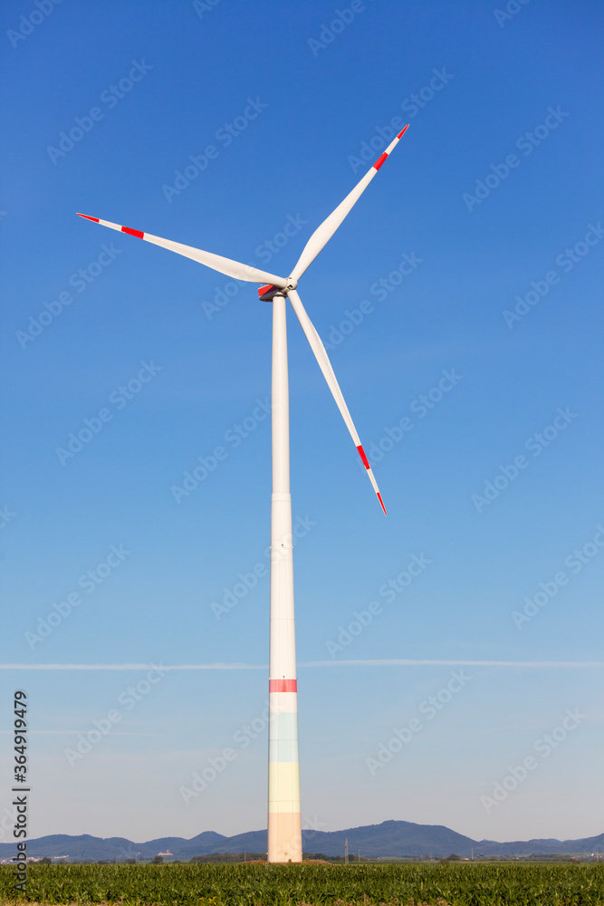 Windmill in front of a landscape with hills producing green electricity Windmill in front of a landscape with hills producing green electricity