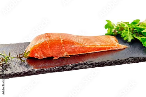 piece of smoked fresh salmon with lettuce leaves on a slate. isolated on white