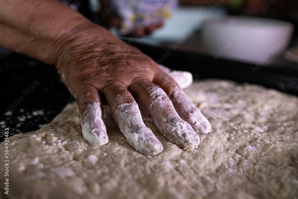 Dough for cake in the pan being stretched by a woman Dough for cake in the pan being stretched by a woman
