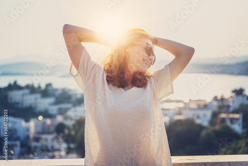 Young beautiful curly woman in sunglasses enjoying life in the summer sun