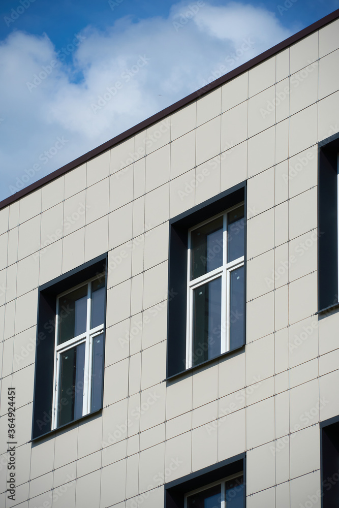 facade of a modern building on a bright Sunny day, siding and Windows, beautiful exterior of the new building facade of a modern building on a bright Sunny day, siding and Windows, beautiful exterior of the new building