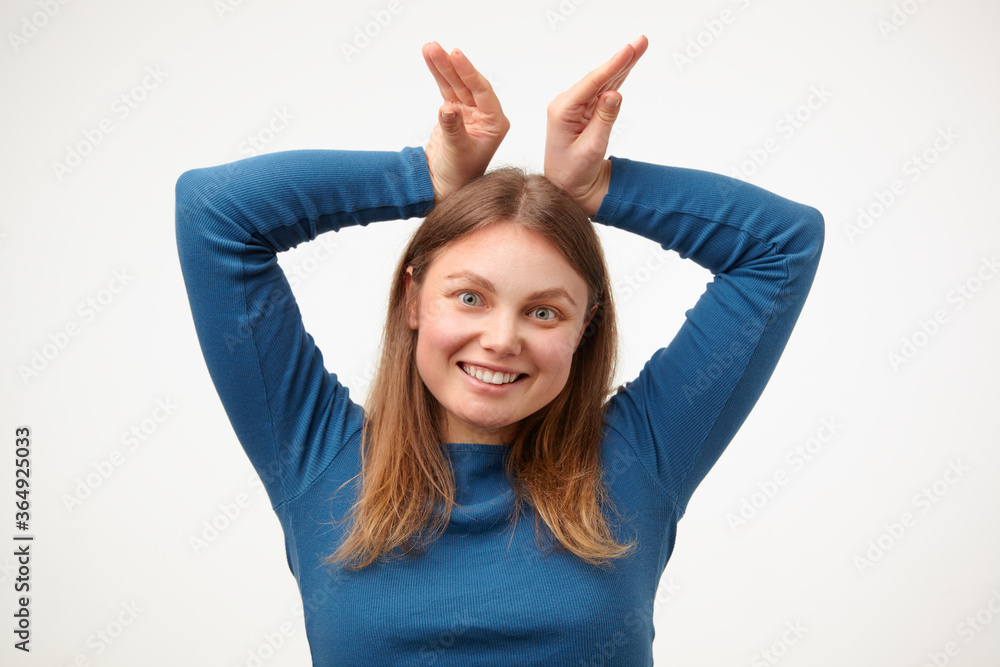 Joyful young pretty white-headed woman with casual hairstyle keeping raised hands above her head and smiling happily at camera while having fun, isolated over white background Joyful young pretty white-headed woman with casual hairstyle keeping raised hands above her head and smiling happily at camera while having fun, isolated over white background