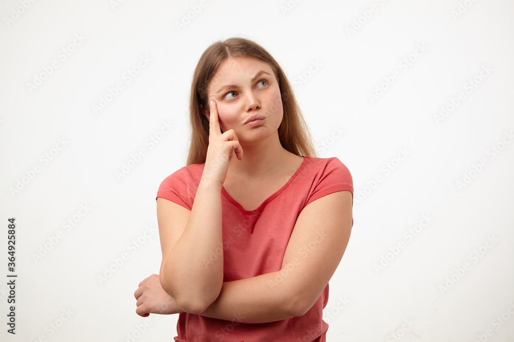 Puzzled young pretty blonde woman with casual hairstyle twisting her mouth while looking pensively aside and leaning head on raised hand, posing over white background Puzzled young pretty blonde woman with casual hairstyle twisting her mouth while looking pensively aside and leaning head on raised hand, posing over white background